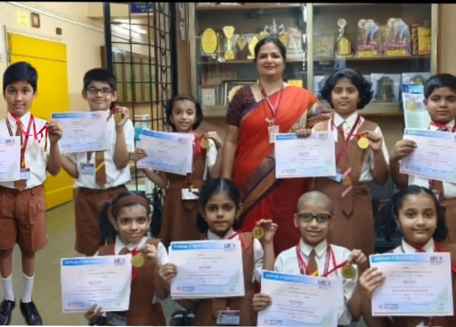 Students proudly displaying their awards and certificates for their outstanding achievements in various competitions and examinations at AK Joshi CBSE School in Thane, representing excellence and success.