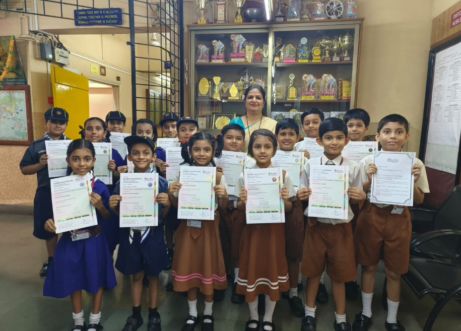 Students proudly displaying their awards and certificates for their outstanding achievements in various competitions and examinations at AK Joshi CBSE School in Thane, representing excellence and success.