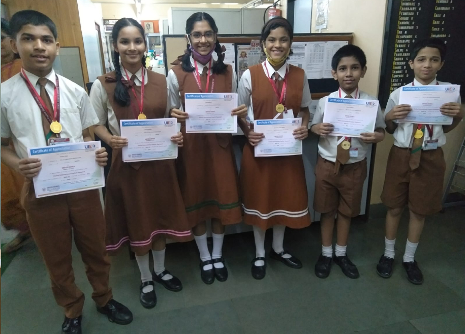 Students proudly displaying their awards and certificates for their outstanding achievements in various competitions and examinations at AK Joshi CBSE School in Thane, representing excellence and success.