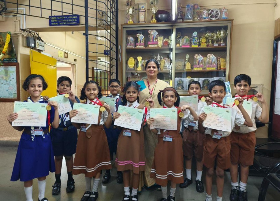 Students proudly displaying their awards and certificates for their outstanding achievements in various competitions and examinations at AK Joshi CBSE School in Thane, representing excellence and success.